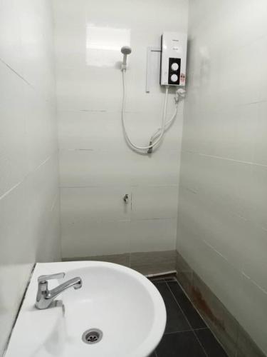 a bathroom with a white sink and a shower at Aeropod Hostel Economy Deluxe King Room in Kota Kinabalu