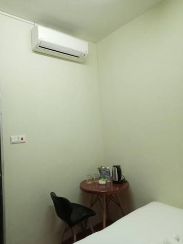 a room with a table and a chair and a bed at Aeropod Hostel Economy Deluxe King Room in Kota Kinabalu