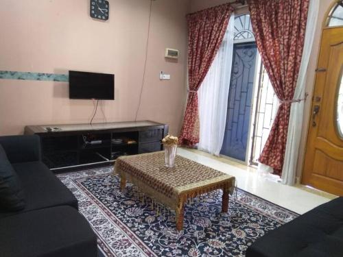 a living room with a couch and a table and a door at Nafili homestay 3bd 2br in Kota Bharu