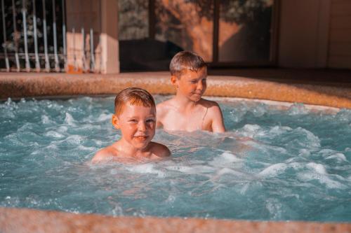two young boys swimming in a hot tub at Waterfront Retreat At Wattle Point in Paynesville