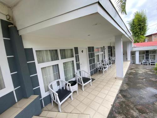 a patio with chairs and windows on a building at Khas Parapat in Parapat
