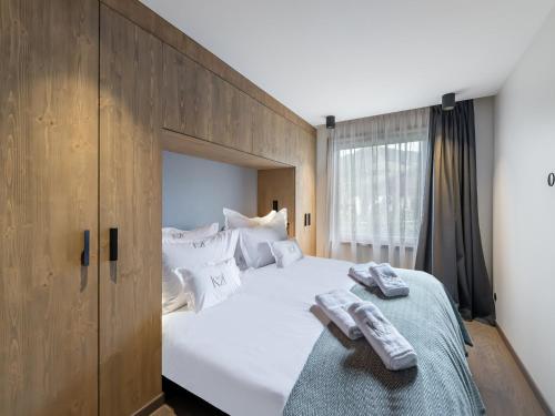 une chambre avec un grand lit blanc avec des serviettes dessus dans l'établissement Appartement Neuf, Jardin Privé, 3 Chambres, Megève Mont d'Arbois - FR-1-569-73, à Megève