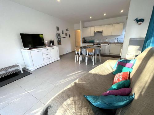 un salon avec un canapé et une cuisine dans l'établissement Terrasse au calme, cœur de Bénodet, appartement à 400m de la plage avec parking privatif - FR-1-481-133, à Bénodet