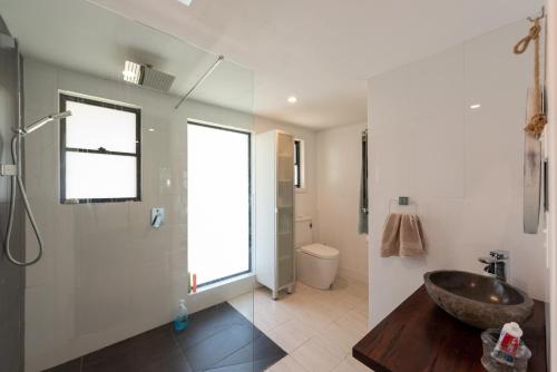 La salle de bains est pourvue d'un lavabo et d'une douche en verre. dans l'établissement Central Coast-Spacious House 5 minutes drive to beach, à Tumbi Vmbi