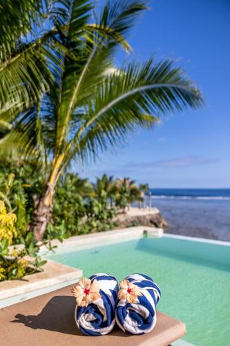two flip flops sitting next to a swimming pool at Savasi Island Resort in Savusavu