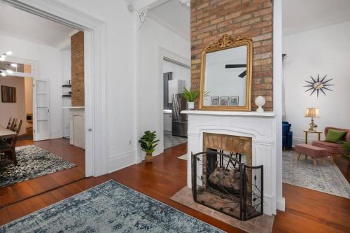 a living room with a fireplace and a mirror at Beautifully Updated New Orleans House *sleeps 6* in New Orleans
