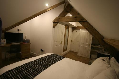a bedroom with a bed and a desk in a attic at Caemorgan Mansion in Cardigan