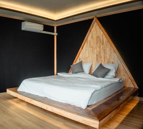 - une chambre avec un lit et une tête de lit en bois dans l'établissement JADAE HOUSE Doichang, à Ban Huai Khai
