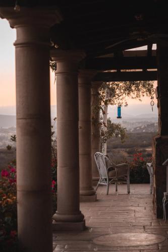 a porch with a table and a chair on it at Viña Calabria in Valle de Guadalupe