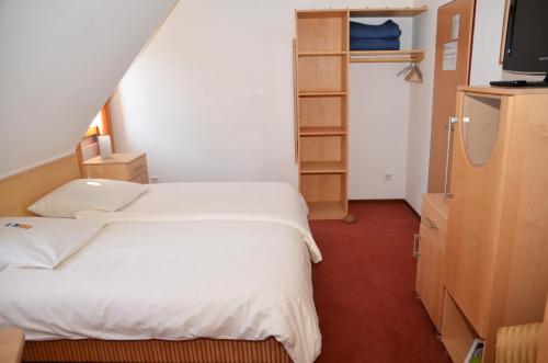 a bedroom with a white bed and a closet at velcrea in Willebadessen