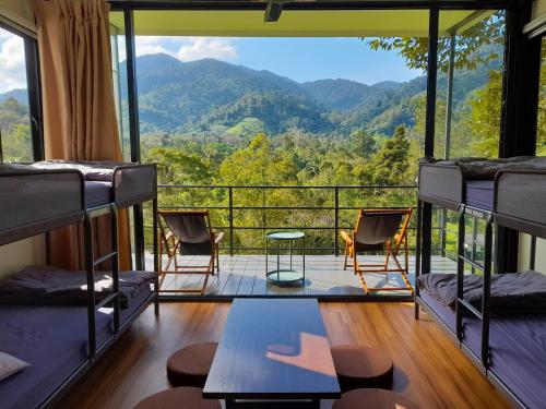 een kamer met stapelbedden en uitzicht op de bergen bij The Hill in Kampong Sum Sum
