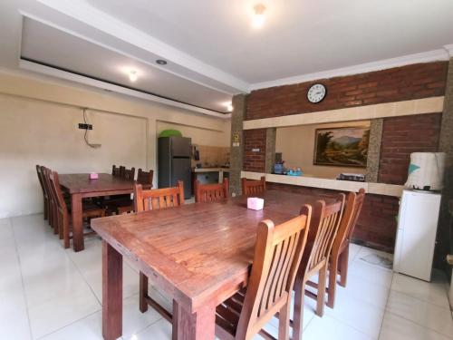 een keuken en eetkamer met een houten tafel en stoelen bij Rumah Kami Guest House in Yogyakarta