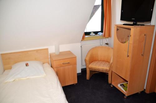 a small bedroom with a bed and a chair at velcrea in Willebadessen