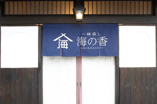 a blue and white sign on the side of a building at 釣りスポットの松部漁港まで徒歩1分-ファミリー&釣り好きに大人気の宿 in Katsuura