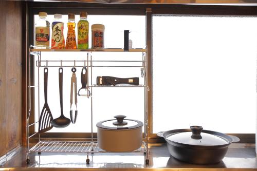 a kitchen with two pots and pans on a shelf at 徒歩1分で行ける秘密のビーチ-ファミリー&釣り好きに大人気の宿 in Katsuura