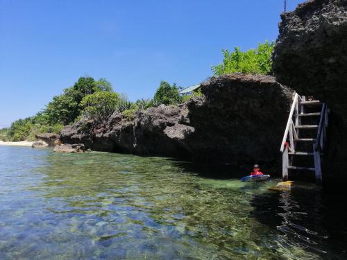 a person in a kayak in the water next to a cave at Almare Guest House Siquijor in San Juan