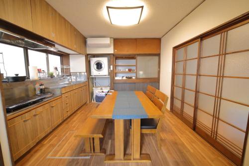 a large kitchen with a wooden table in it at 釣りスポットの松部漁港まで徒歩1分-ファミリー&釣り好きに大人気の宿 in Katsuura