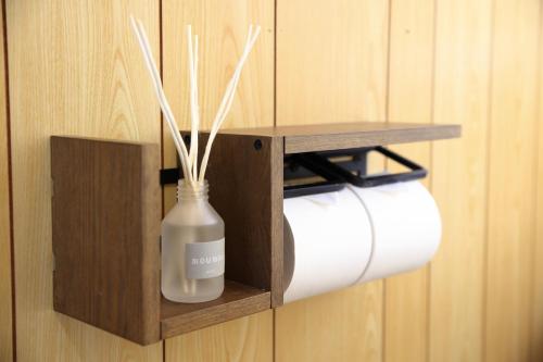 a toilet paper roll holder with a bottle of soap at 釣りスポットの松部漁港まで徒歩1分-ファミリー&釣り好きに大人気の宿 in Katsuura