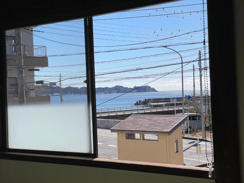a window of a building with a view of the water at 釣りスポットの松部漁港まで徒歩1分-ファミリー&釣り好きに大人気の宿 in Katsuura