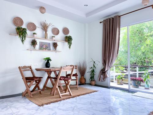 a dining room with a table and chairs and a window at Panwa beachfront apartments in Ban Ao Makham