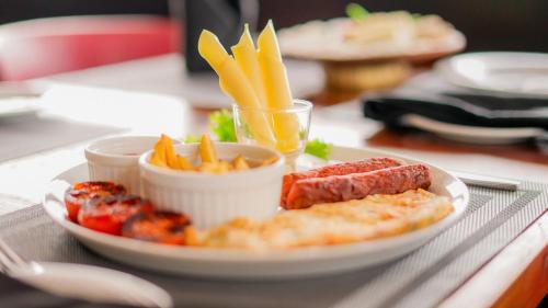 un piatto di cibo con formaggio, carne e patatine fritte di Royal Classic Resort a Kandy