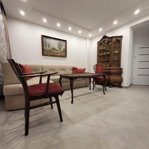 a living room with a couch and a table and chairs at Jaukus būstas Kintai in Kintai