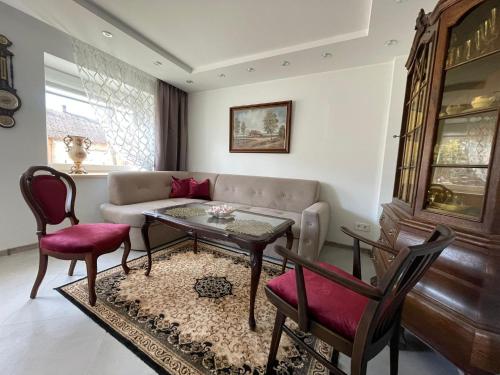 a living room with a couch and a table and chairs at Jaukus būstas Kintai in Kintai