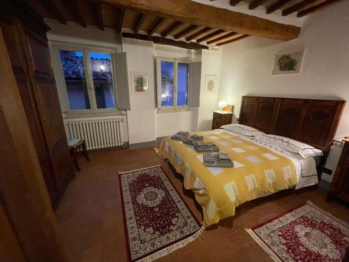 een slaapkamer met een bed en twee tapijten bij PULCINELLA appartamento tipico centro storico in Montepulciano