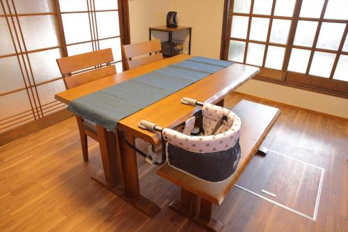 a dining room table with a basket on a chair at 徒歩1分で行ける秘密のビーチ-ファミリー&釣り好きに大人気の宿 in Katsuura