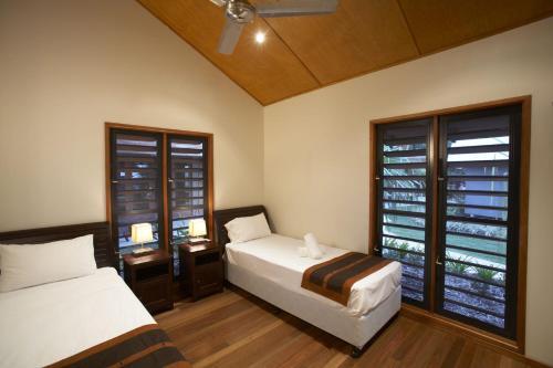 a bedroom with two beds and a window at Pure Magnetic Villa 6 in Nelly Bay