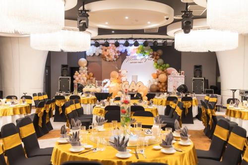 頭頓的住宿－Premier Pearl Hotel Vung Tau，宴会厅设有黄色桌子、椅子和气球
