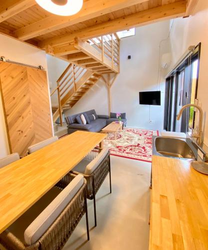 a kitchen and living room with a large wooden table at Hotel Little Swiss House in Motobu