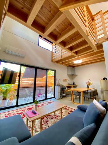 a living room with a blue couch and a table at Hotel Little Swiss House in Motobu