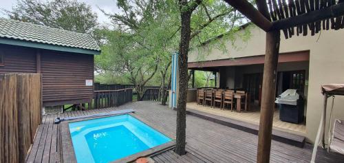una piscina en una terraza junto a una casa en Tranquillity Holiday Home, en Marloth Park