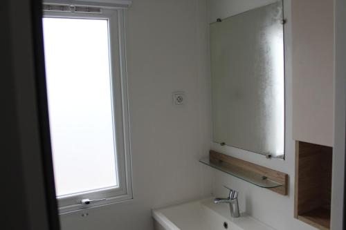 a bathroom with a sink and a mirror and a window at Prendre Un Bol D'air a Piriac sur Mer in Piriac-sur-Mer