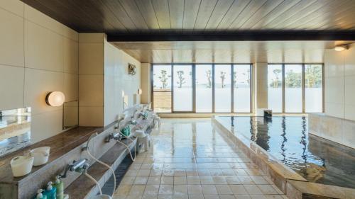 een grote kamer met een zwembad met water bij Yunoko Umi To Yuyake in Mizumata