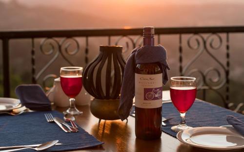 a bottle of wine sitting on a table with two glasses at Ceylon Breeze in Kandy