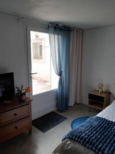 a bedroom with a bed and a large window at Chambre d'hôte Chez Josie in Beaucaire