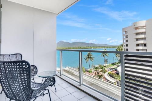 a balcony with chairs and a view of the ocean at 602 Harbour Lights Studio - Pool Gym and Sauna in Cairns