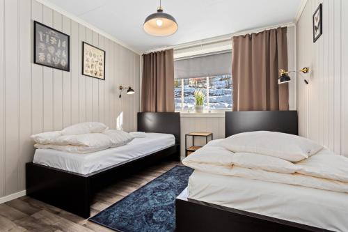 a bedroom with two beds and a window at Sagi 1 Privat Apartment in Hafslo