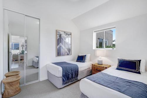 a hotel room with two beds and a mirror at The Lookout at Iluka Resort Apartments in Palm Beach
