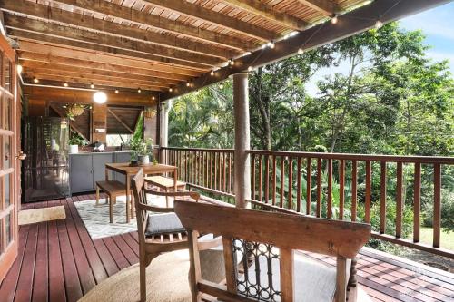a wooden deck with a table and chairs on it at Bindi Treehouse - Elevated Pole Home in Freshwater