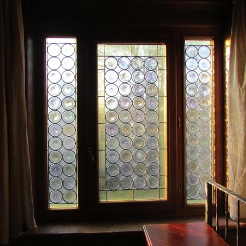 three stained glass windows in a room with a table at Agriturismo La Costa in Crema