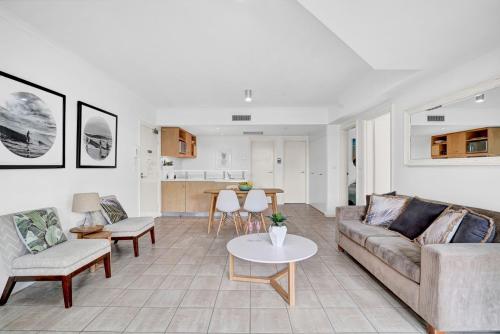 a living room with a couch and a table at Poolside at Iluka Resort Apartments in Palm Beach