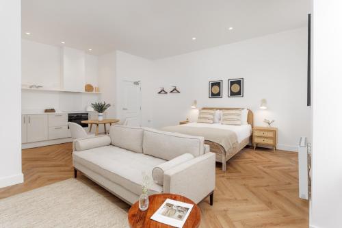40 Renshaw Apartments في ليفربول: غرفة نوم بيضاء مع سرير وأريكة