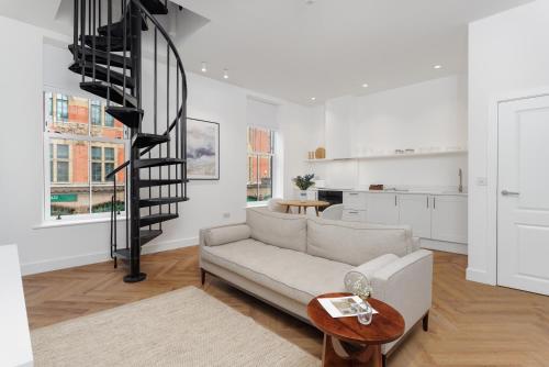 a living room with a couch and a spiral staircase at 40 Renshaw Apartments in Liverpool