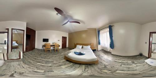 Victoria Mews Hotel في كامبالا: غرفة نوم بسرير ومروحة سقف