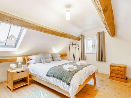 a bedroom with a bed and a wooden floor at Kings Barn in Weston under Lizard