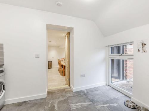 an open hallway with a dining room and a window at Kings Barn in Weston under Lizard