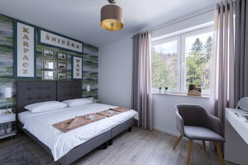 une chambre avec un lit, une chaise et une fenêtre dans l'établissement APARTAMENT KONOPNICKIEJ 11/23, à Karpacz